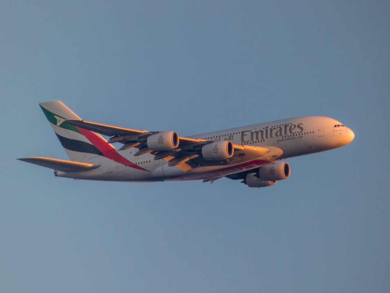 Emirates Airbus A380 flying high during sunset, capturing elegance and aviation engineering.